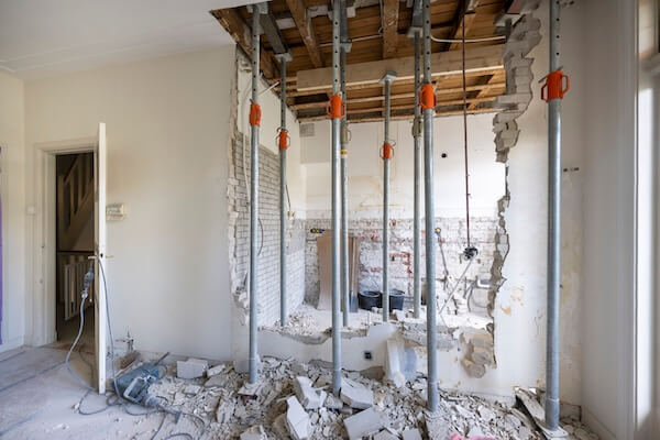 Doorgebroken muur met stempels voor versteviging