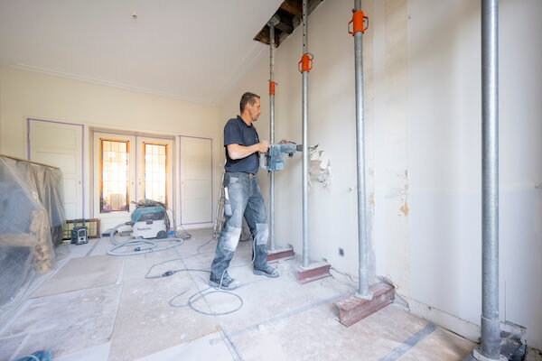 aannemer bij muur met grote boor