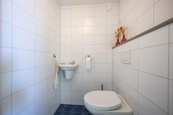 Nieuwe inrichting van toilet, witte tegels