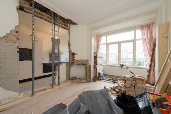 De tussenmuur is volledig gesloopt. De stalen balk wordt door stempels op zijn plaats gehouden. 