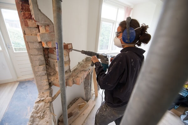 doorbreken van een muur door een aannemer met een pneumatische beitel