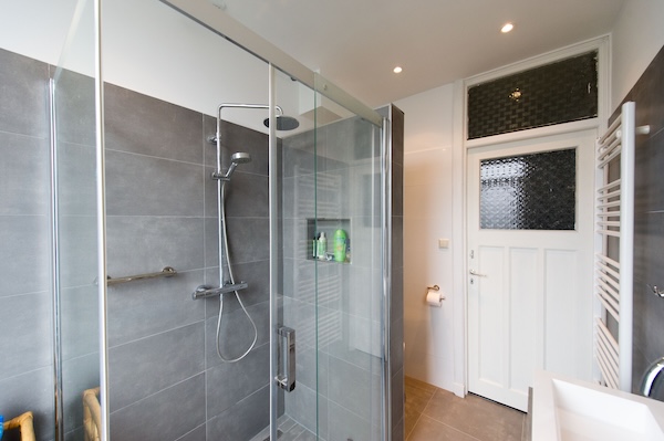 Badkamer met glazen toestel en designradiator